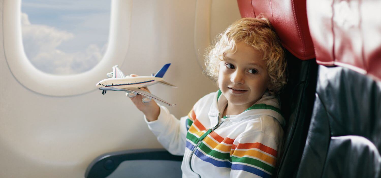 Enfant dans un avion pendant un voyage long courrier en famille, illustration du décalage horaire